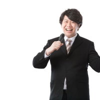 マイク片手に自社製品を紹介する男性広報IR担当者の写真