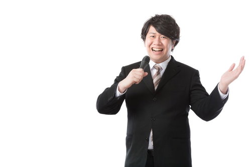 マイク片手に自社製品を紹介する男性広報IR担当者