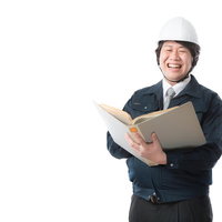 設計書を手に笑顔を見せる1級建築士の男性の写真