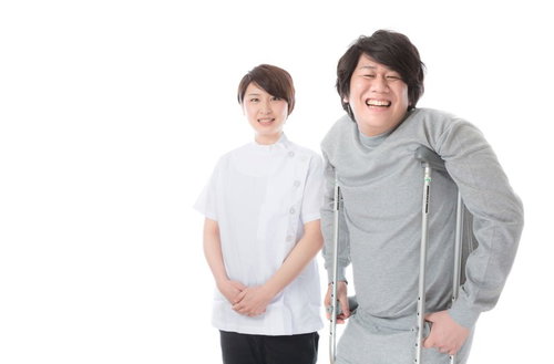 松葉杖でリハビリテーション中の患者と理学療法士