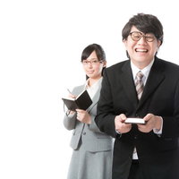 あらゆる業務を支える敏腕秘書が名刺を手に笑顔で立つの写真