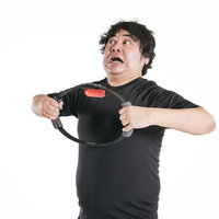 トレーニングリングを引っ張り背筋を強化する男性の写真