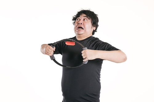 トレーニングリングを引っ張り背筋を強化する男性