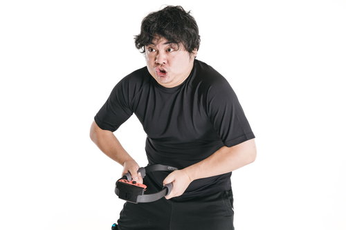 ゲームコントローラーを握り真剣な表情でプレイする男性