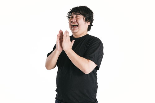 感動して両手を合わせて拍手を送る男性のポートレート