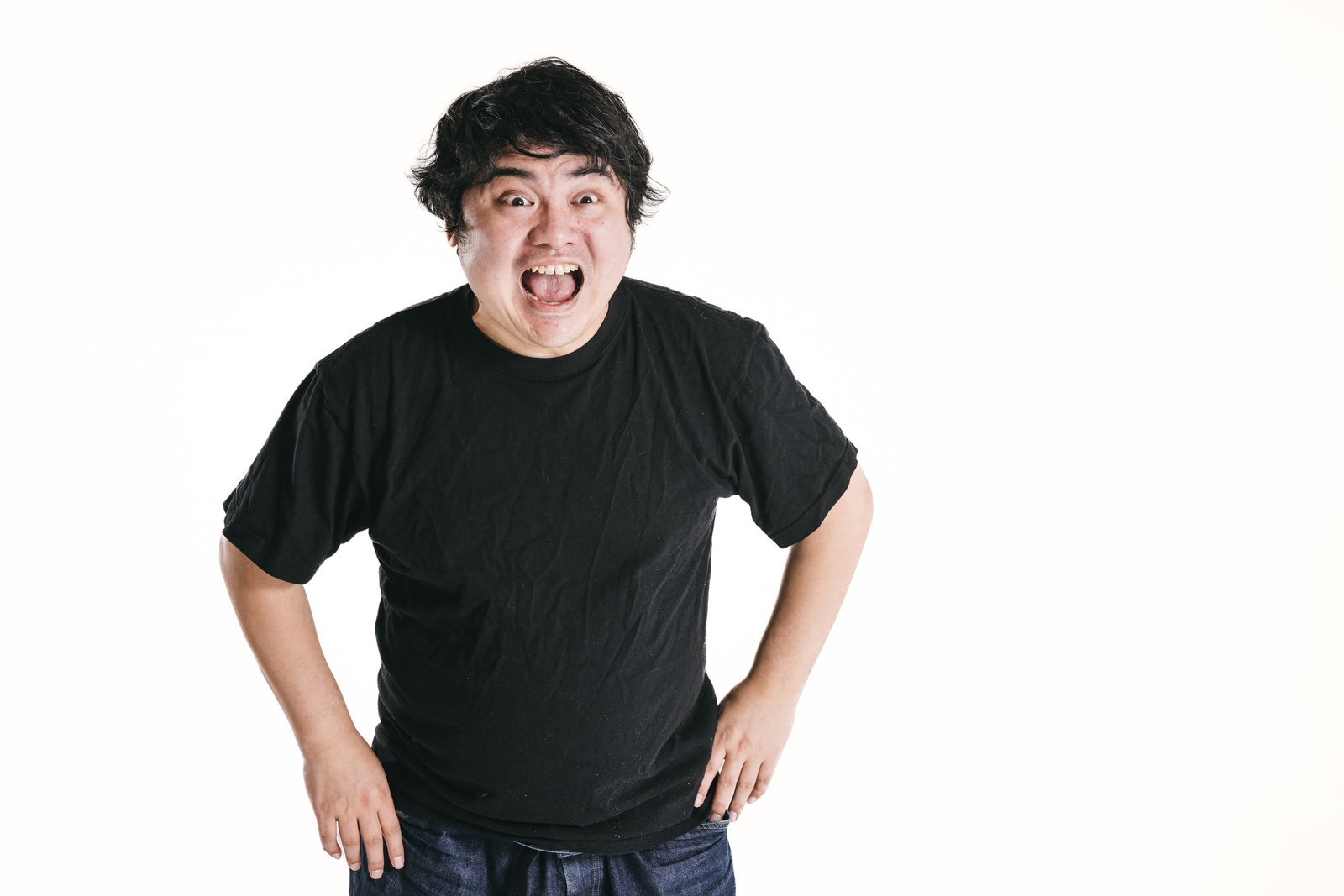 黒いTシャツを着た男性が驚いた顔で口を開けている写真［モデル：段田隼人］