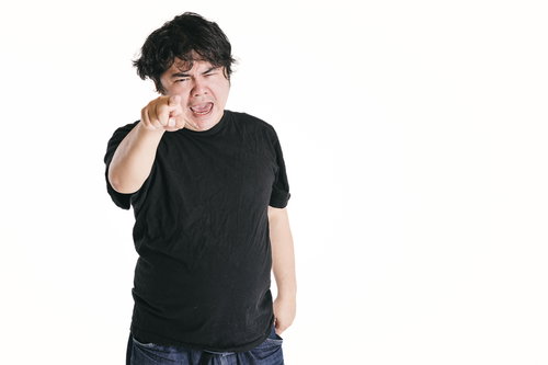 指をさして憤慨する男性
