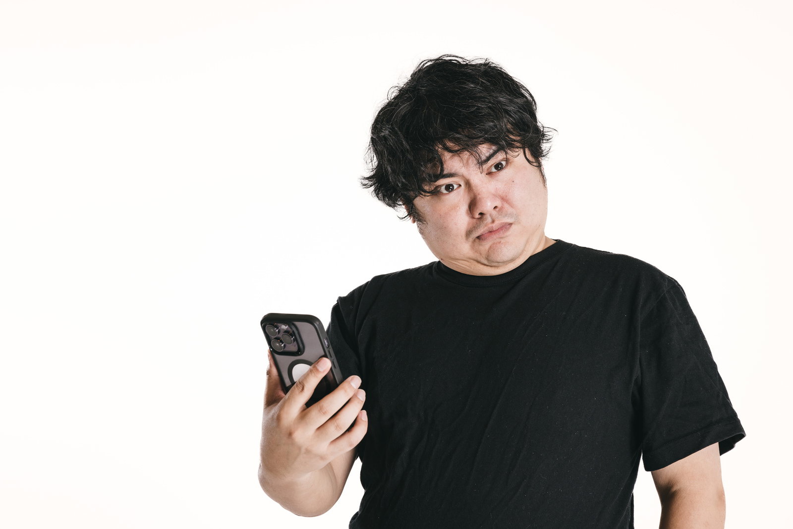 スマートフォンを見て驚いた表情の男性［モデル：段田隼人］