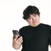 スマホを手放せない男性の驚愕した表情と誤爆時の反応の写真