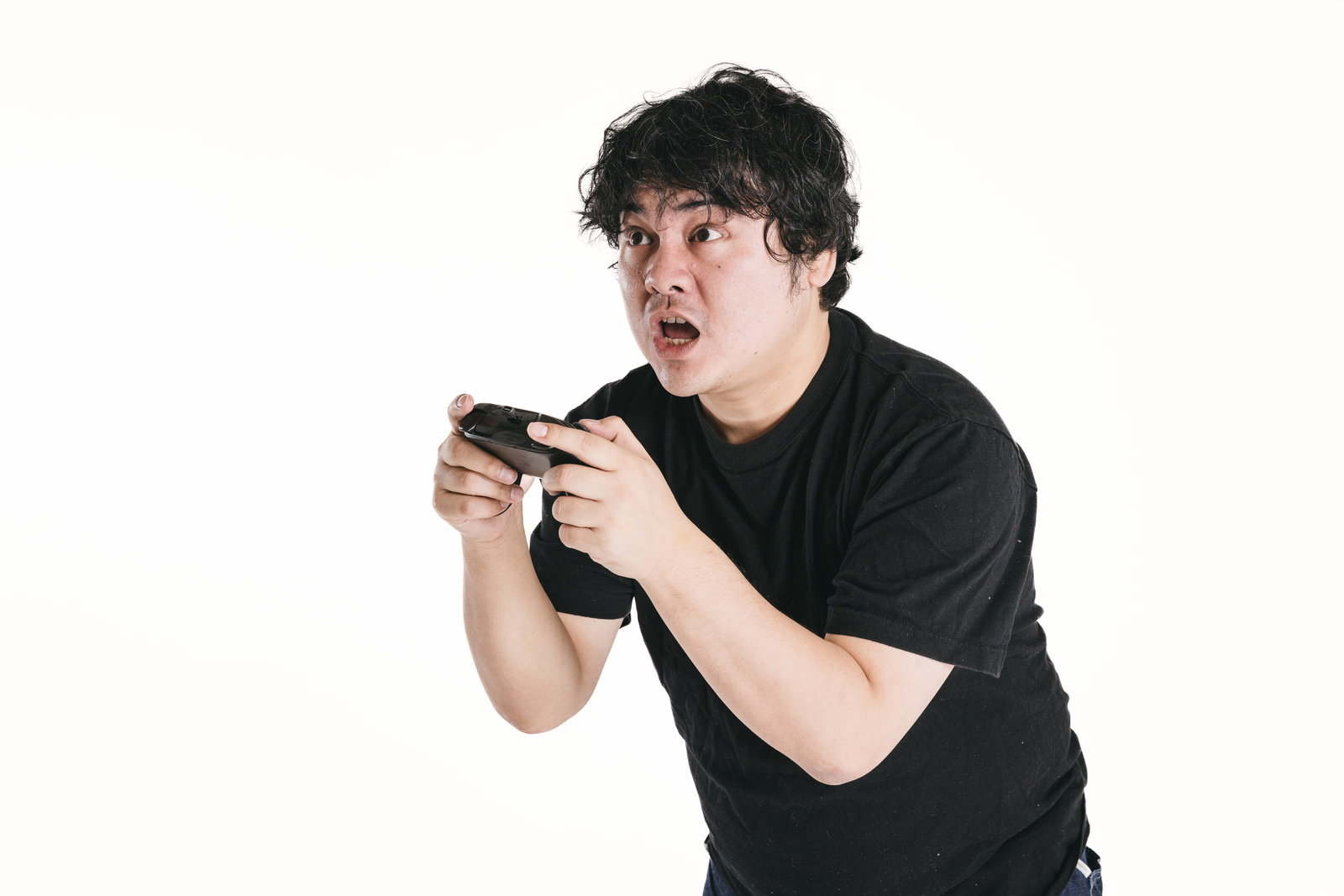ゲームをプレイしながら真剣な表情で集中する男性［モデル：段田隼人］