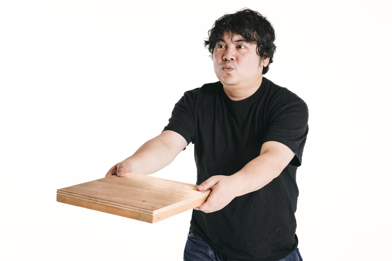 木製トレーを持つ男性が配膳トレーニングの動作をしている［モデル：段田隼人］