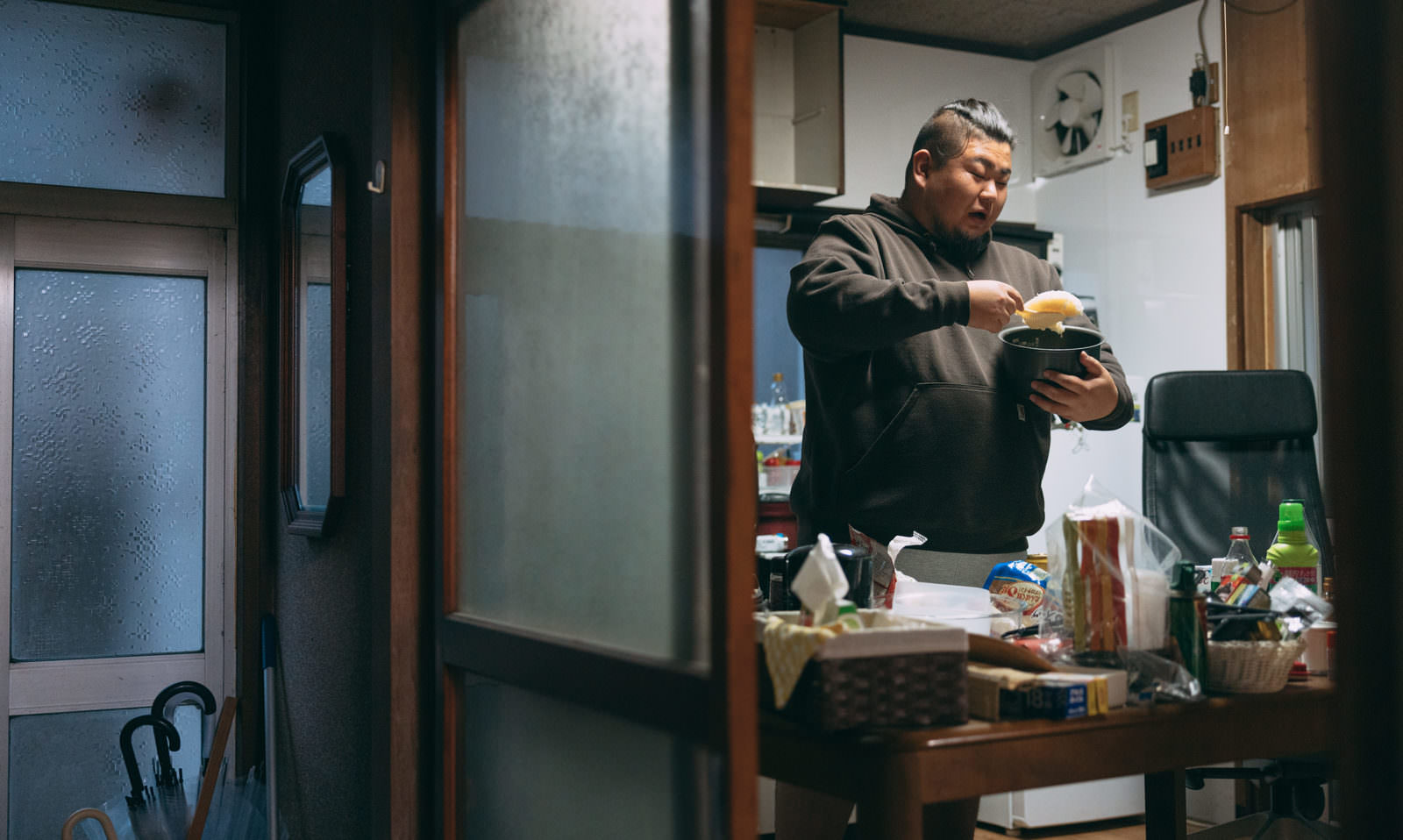 炊飯ジャーを持ってご飯を食べている男性［モデル：ノリックス］