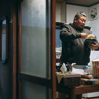 炊飯ジャーごとご飯を食べる男性の暴飲暴食の写真