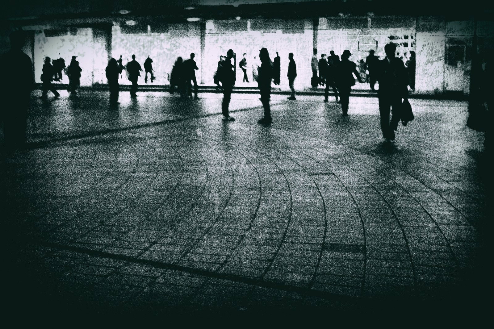 駅前の広場で待ち合わせや通勤の人々が行き交うモノクロ写真