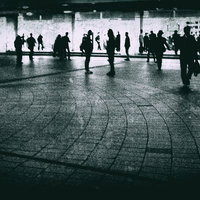 駅前の広場で往来する人々のノイズ効果のモノクロの写真