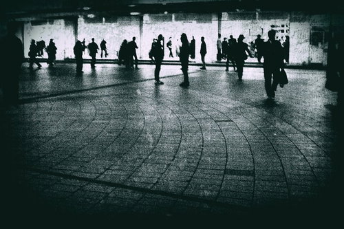 駅前の広場で往来する人々のノイズ効果のモノクロ