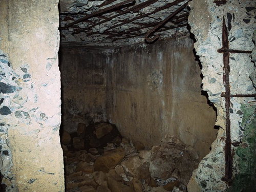 鉄筋がむき出しになり瓦礫が床に散らばる陸軍野砲陣地トーチカ内部