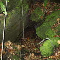 苔むした岩に隠れた陸軍野戦病院壕口の写真
