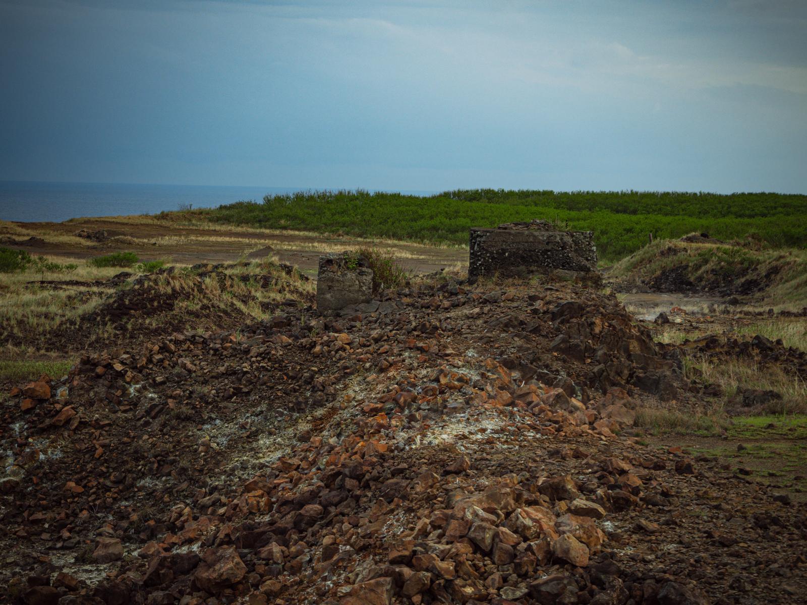 硫黄島の荒地に立つコンクリート製のトーチカ遺構と砕石の風景