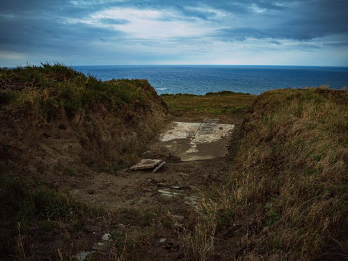 硫黄島の米軍施設跡塹壕から望む曇天の海岸線
