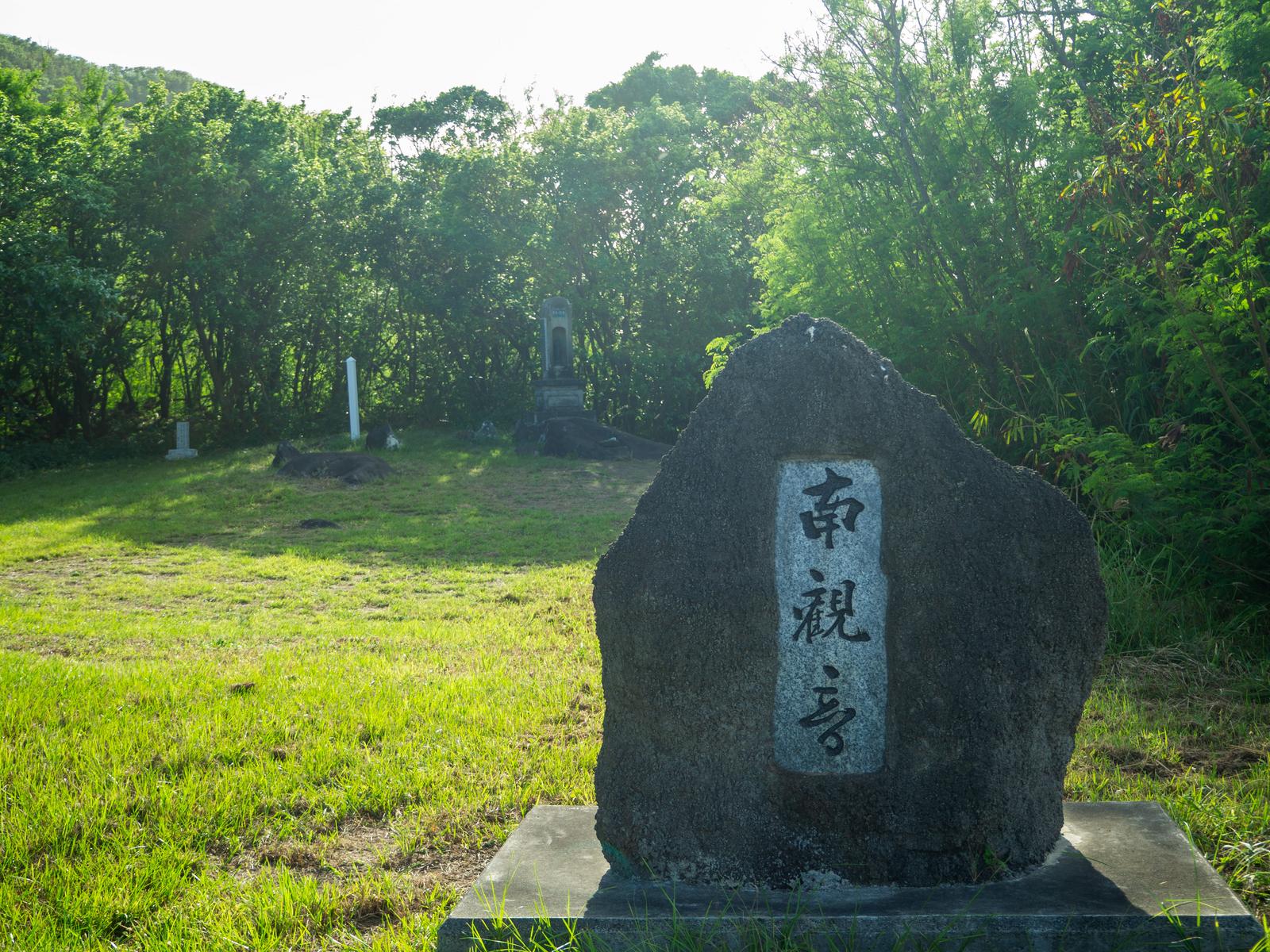 Black stone monument of the Minamimonji cenotaph and the surrounding verdant forest on Iwo Jima