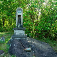 自然に囲まれた慰霊の石碑の写真
