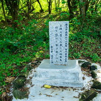 緑に囲まれた石碑に刻まれた歴史の写真