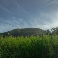 硫黄島摺鉢山の緑豊かな草原と青空の写真