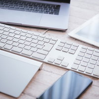 白いキーボードとトラックパッドが置かれたエンジニアのデスクの写真