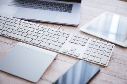 白いキーボードとトラックパッドが置かれたエンジニアのデスク