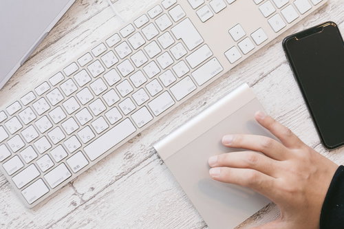 キーボードの横でトラックパッドを操作する右手