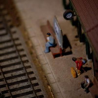 ホームに人形が立つ鉄道模型のミニチュア駅ジオラマの写真