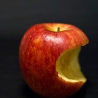 右下が三日月型に食べられたかじった後の赤いりんごの写真