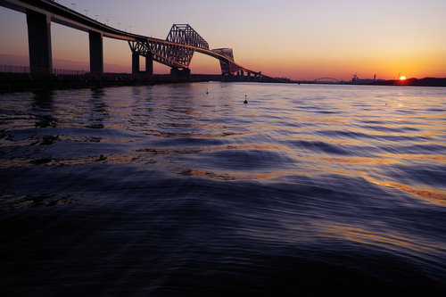 夕焼け色に染まる東京ゲートブリッジと東京湾