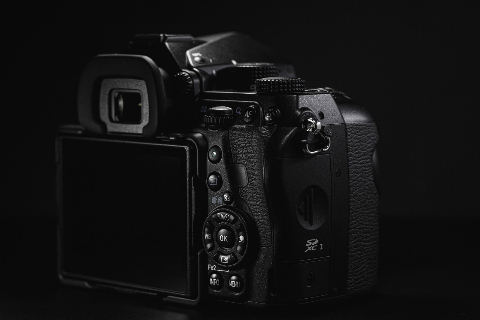 暗い背景の中に浮かび上がるPENTAX K-1 Mark IIの操作ボタン部分