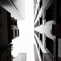 都会のビルの谷間から見上げる空の写真