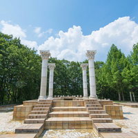 公園にある白い柱の神殿風オブジェの写真
