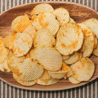 木製ボウルに盛られたおやつのポテチ、黄金色に揚げたスナック菓子の写真