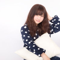寝起き頭が回らない女子がクッションを抱えるの写真