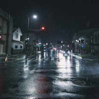 深夜の雨に濡れた深妙通り南交差点の街灯と信号の写真