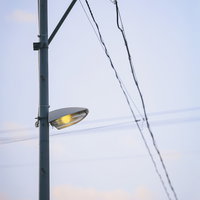 夕暮れ時に点灯する福島県小高の街灯と電柱の夜景の写真