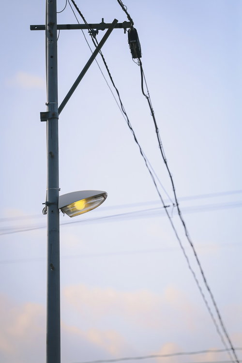 夕暮れ時に点灯する福島県小高の街灯と電柱の夜景