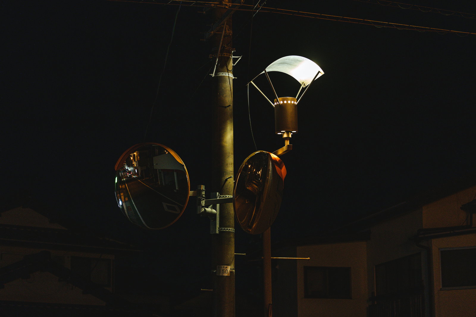 深夜の広野町の通りを照らす街灯と円形ミラー