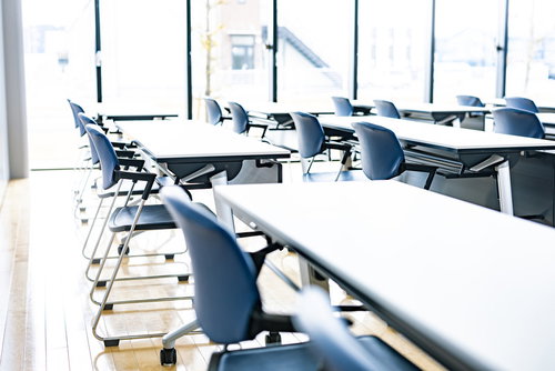 ミーティングルームのデスクと椅子が並ぶ会議室