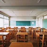 大熊インキュベーションセンターの旧校舎の教室で配列された木製机と椅子の写真