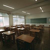 大熊インキュベーションセンターの教室跡、木製机と黒板が残るの写真