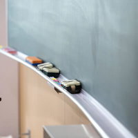 大熊インキュベーションセンターの廃校舎に並ぶ机と黒板の写真