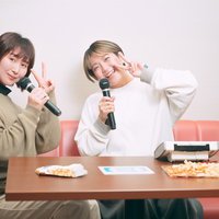 マイクを持ってカラオケを楽しむ女性ふたりの写真
