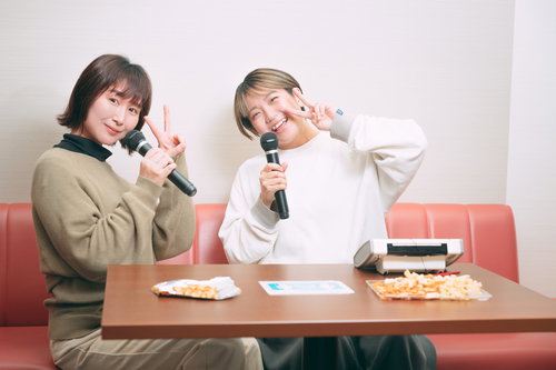 マイクを持ってカラオケを楽しむ女性ふたり