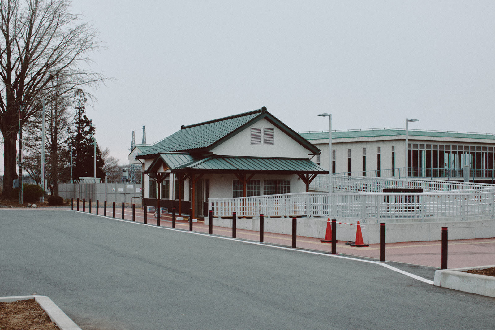 Panoramic view of the white-walled station building with a green roof and the square in front of Yonorin Station, Fukushima Prefecture